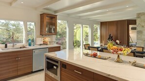 A modern kitchen with wooden cabinets, a marble countertop, and a fruit bowl. - 3954 Lilli Pad - Remodeled, Private Primary Suite (Carmel)