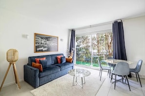 Un salon moderne comprenant un canapé, une table basse et un coin repas avec des chaises et une table.