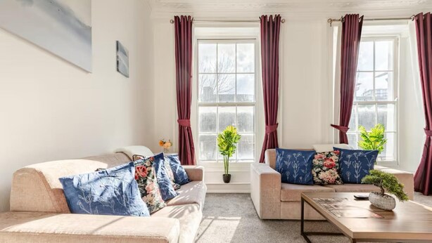 Ein Wohnzimmer mit zwei Sofas, einem Couchtisch und einer Zimmerpflanze.