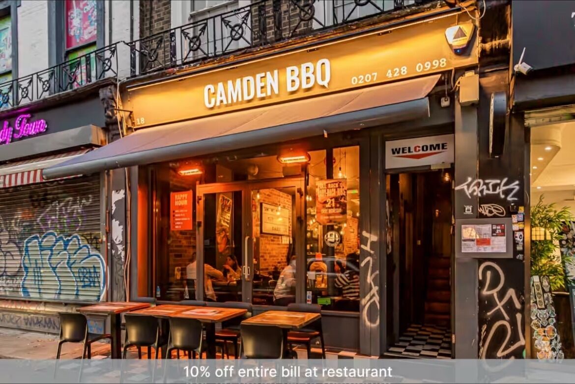 Un restaurant appelé « Camden BBQ » qui dispose d’une terrasse et d’une enseigne au néon.