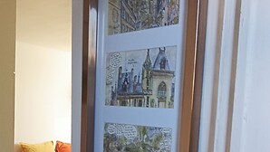 A framed collage of buildings on a wall.