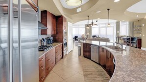Una cocina moderna con una isla curva, electrodomésticos de acero inoxidable y una isla central con un fregadero.