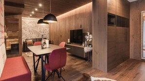 Een moderne eetruimte met een houten tafel, rode stoelen en hanglampen.