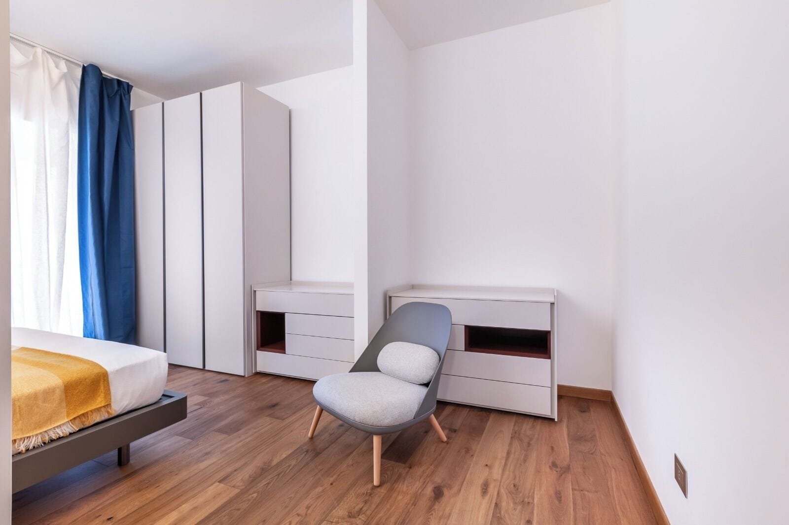Un dormitorio moderno con cama, escritorio y silla.