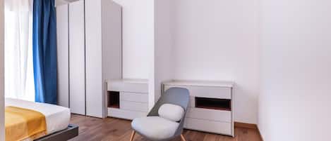 Un dormitorio moderno con cama, escritorio y silla.