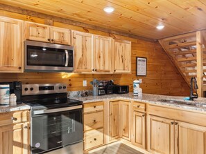 A kitchen with wooden cabinets, a microwave, an oven, and a toaster.