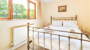 A bedroom with a double bed, a radiator, a window with curtains, and a painting on the wall. - Host Stay Welsford House (Norwich)