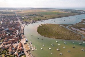 An aerial view of a coastal town with a marina filled with boats, surrounded by residential and commercial buildings. - Host Stay The Hideaway (Wells-next-the-Sea)