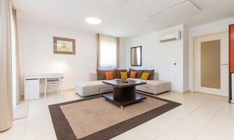 Una sala de estar moderna con un sofá, una mesita, un escritorio y una silla.