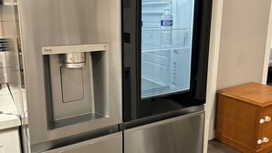 Un refrigerador de acero inoxidable con dispensador de agua, compartimento congelador y fabricador de hielo integrado.