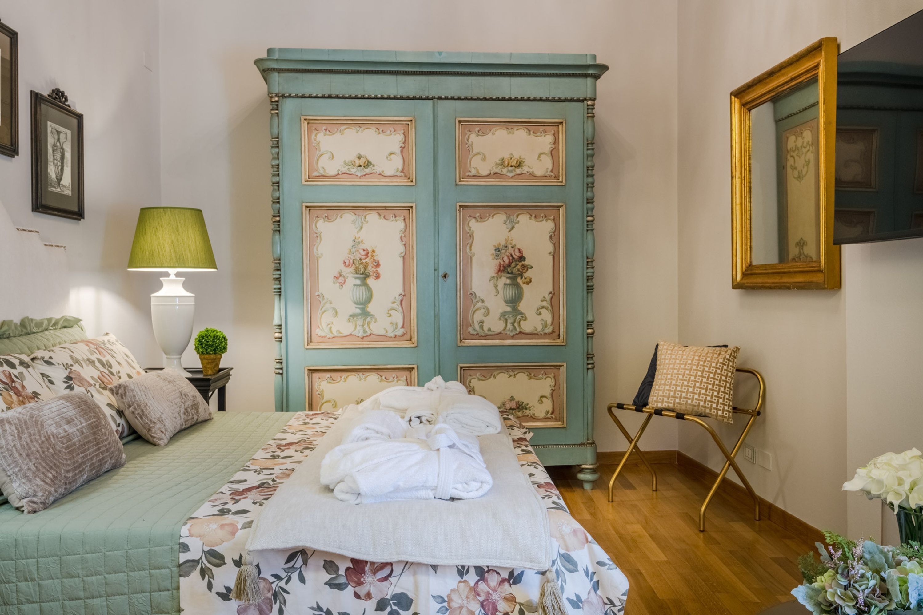 Une chambre à coucher avec un lit, une commode, une chaise et une lampe.