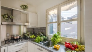 A kitchen with a stove, sink, and window. - The Terrace Retreat in Lucca (Lucca)