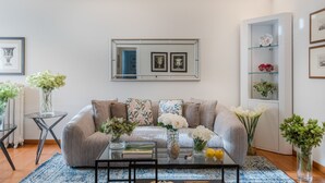 A living room with a sofa, coffee table, and decorative vases. - The Terrace Retreat in Lucca (Lucca)