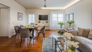 A spacious living room with a dining area, a sofa, and a TV mounted on the wall. - The Terrace Retreat in Lucca (Lucca)