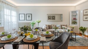 A modern living room with a dining area, featuring a sofa, coffee table, and a dining table set for a meal. - The Terrace Retreat in Lucca (Lucca)