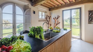 Una cocina con una isla grande, vigas de madera y vistas al exterior.