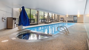 An indoor swimming pool with a clear view of the outside, a changing room, and a reception area.