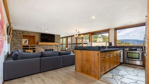 A modern kitchen with a stone backsplash, wooden cabinets, and a built-in oven.