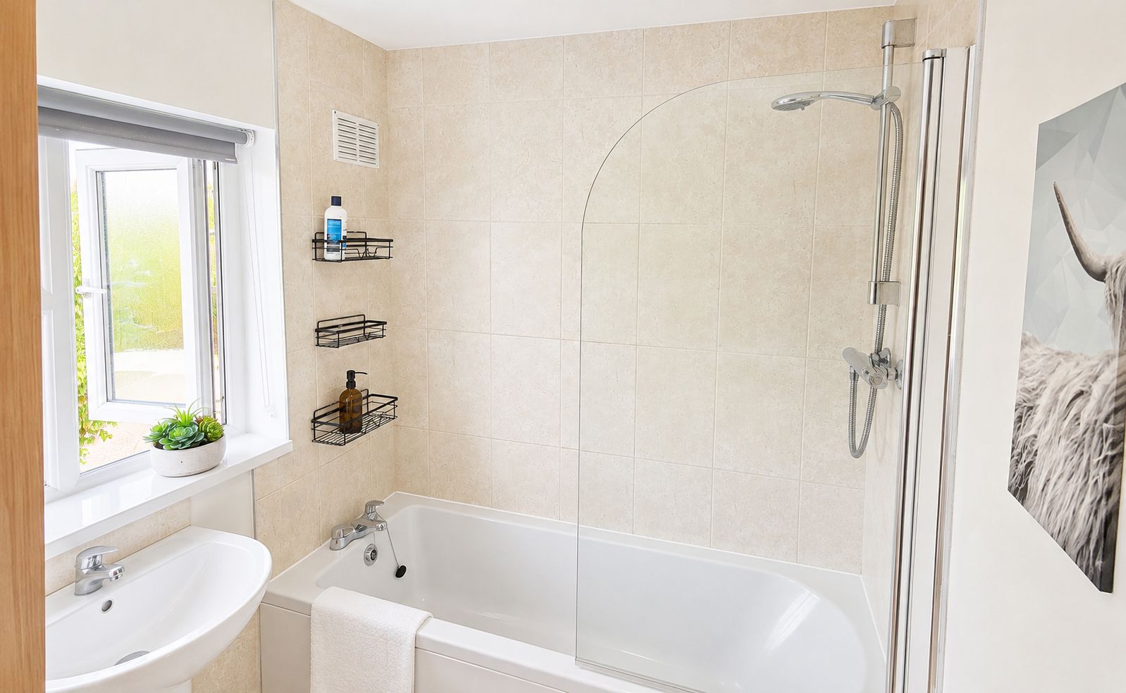 Une salle de bain moderne avec une baignoire, une douche et une fenêtre agrémentée d’une plante.