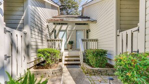 A residential property with a front porch, steps, and a small garden area.