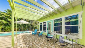 A covered patio with a pool, outdoor seating, and a view of the pool. - Tropical Pool Oasis on 1/4 Acre by Downtown Stuart (Stuart)