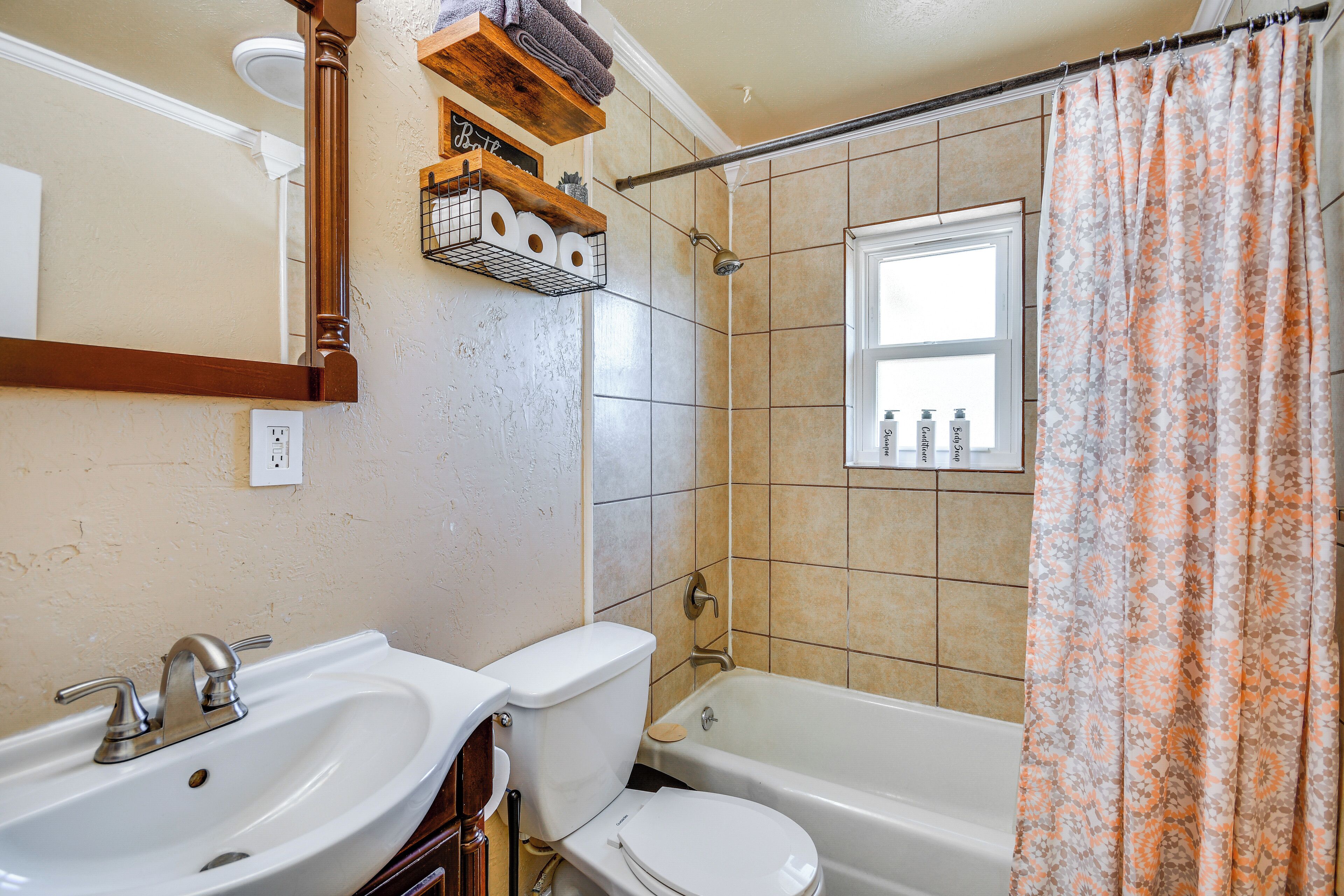 Une salle de bain équipée d’un lavabo, de toilettes, d’une baignoire et d’un rideau de douche.