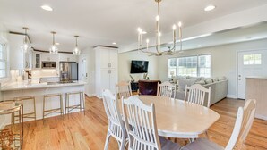 A spacious kitchen with a central island, white cabinetry, and a dining area with a round table and chairs. - Lake Keowee Home w/ Boat Dock in Seneca (Seneca)