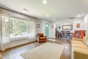 A living room with a sofa, armchair, and a dining table with chairs. - Private Patio & Lake Views: Home in Decatur (Decatur)