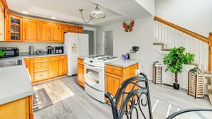 A modern kitchen with wooden cabinets, a gas stove, and a refrigerator.