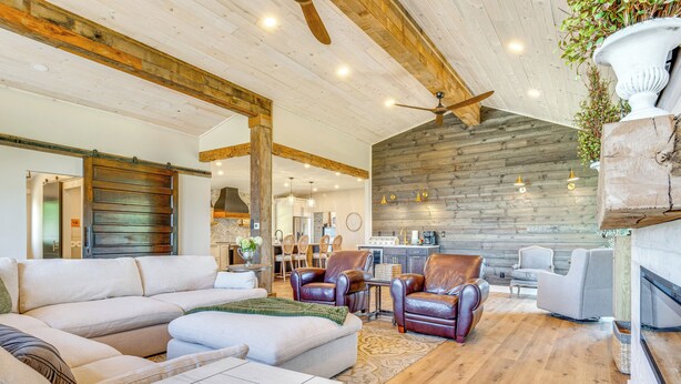 A spacious living area with a large sectional sofa, leather armchairs, and a wooden floor. - Hope Retreat w/ Furnished Deck Near Parks! (Hope)