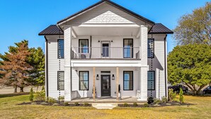 A two-story house with a front porch, a balcony, and a garage. - Hope Retreat w/ Furnished Deck Near Parks! (Hope)