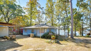 A single-story house with a porch, a small yard, and a view of a lake. - 10 Mi to National Park: Patio at Hot Springs Home (Hot Springs)