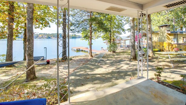 A covered outdoor area with a view of a lake, trees, and a dock. - 10 Mi to National Park: Patio at Hot Springs Home (Hot Springs)