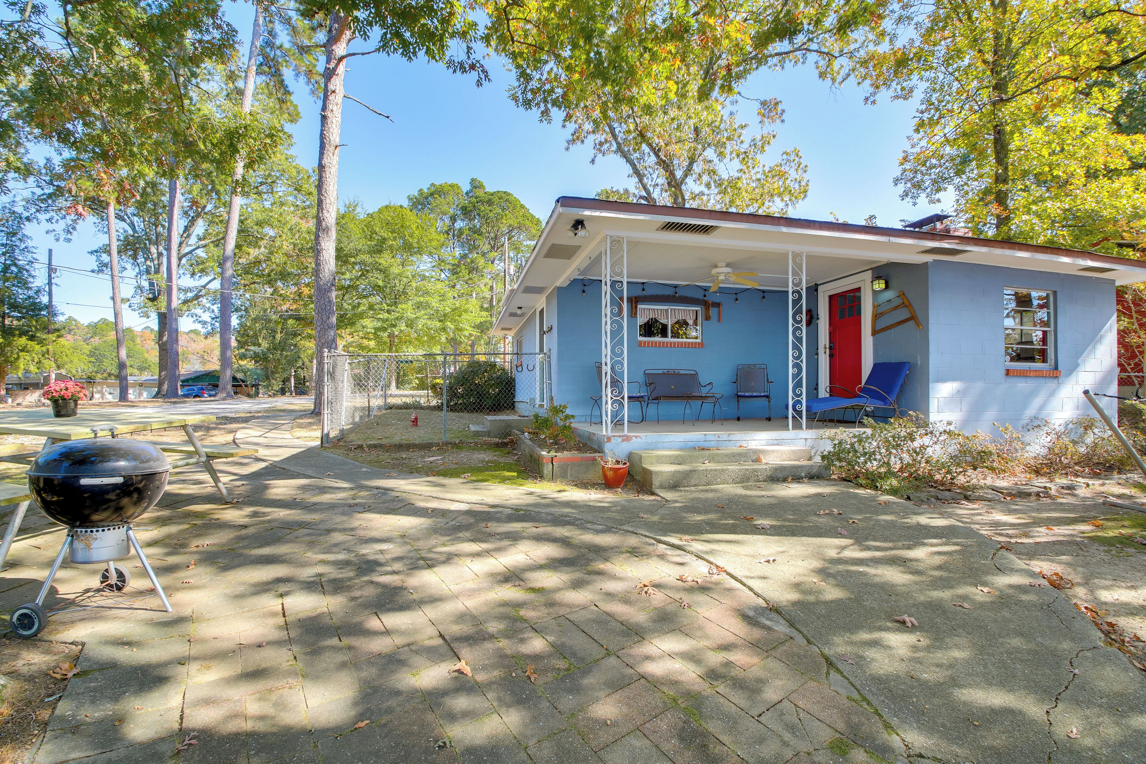 A small house with a porch, a barbecue grill, and a patio area.