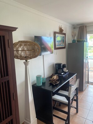 A room with a desk, chairs, a television, a coffee maker, and a refrigerator. - "Ti Kaz An Nou" Studio with Ocean View - Marie Galante - Not Overlooked (Sainte-Anne)