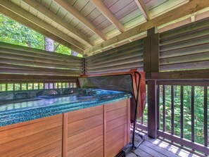 A wooden spa area with a hot tub, wooden deck, and surrounding greenery. - 1BR, hot tub, jacuzzi.  Free attraction tickets! (Gatlinburg)