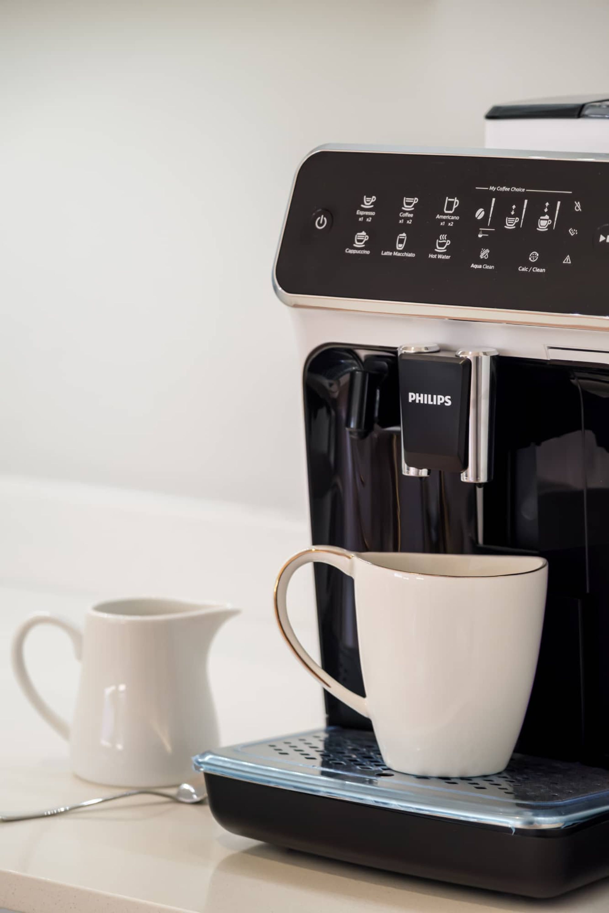 A coffee maker with a control panel and a cup on a scale.