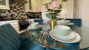 A modern kitchen with checkered backsplash, white cabinets, and stainless steel appliances.
