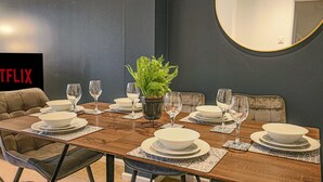 A dining room with a wooden table set for six, surrounded by cushioned chairs. - Host Stay Chicksands Avenue (Milton Keynes)