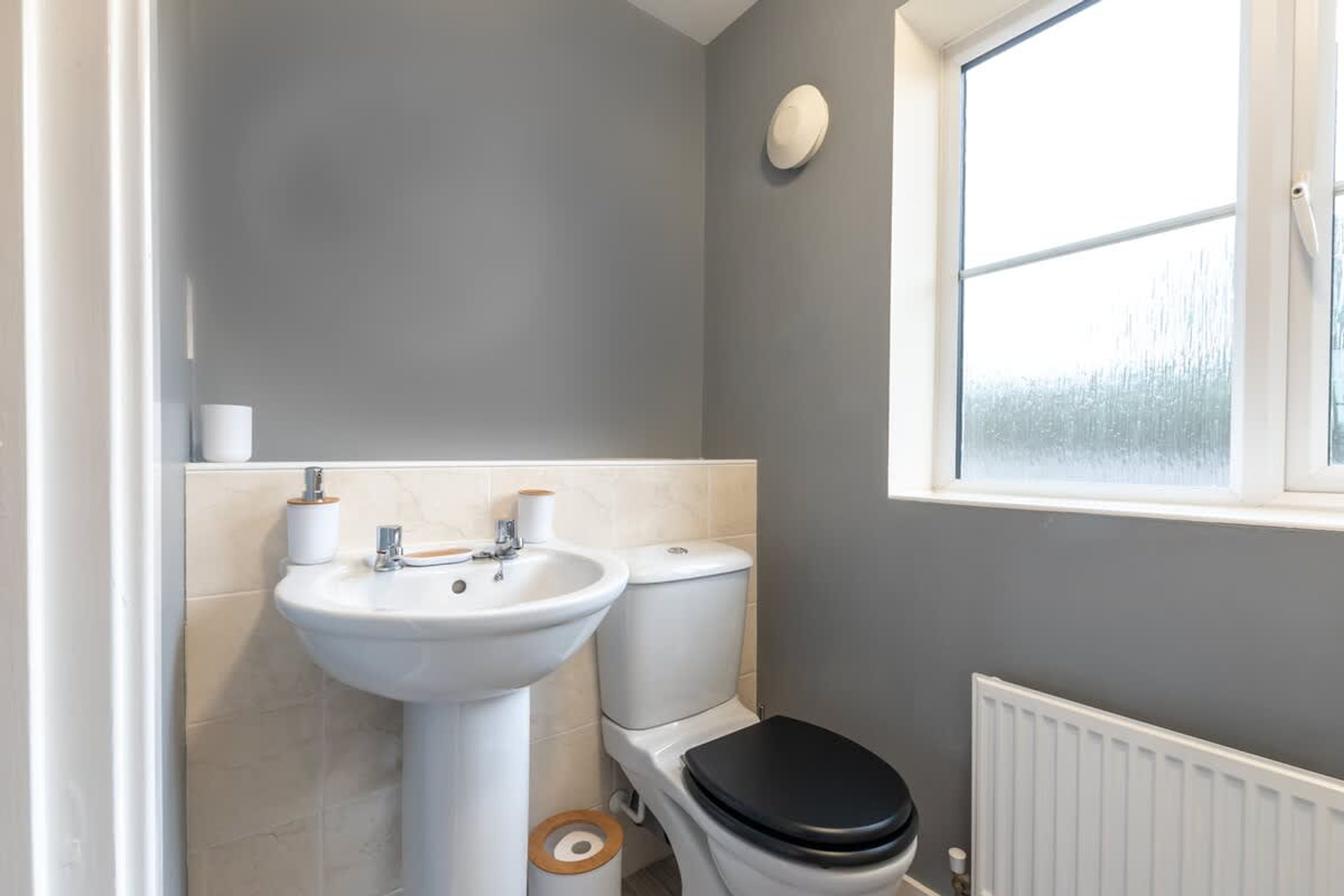 Ein Badezimmer mit Waschbecken, Toilette und Fenster.