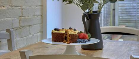A table with a cake and a vase of flowers.