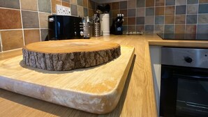 Una cocina con encimera de madera, horno empotrado y salpicadero de azulejos.