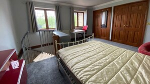 A bedroom with a bed, a desk, a chair, a wardrobe, and a window. - Host Stay Studley Knapp (Milton Keynes)