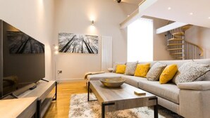 En moderne stue med sofa, sofabord og et billede på væggen.