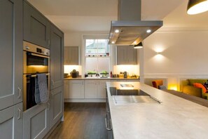 Enjoy cooking in this well-equipped kitchen with a central island, oven, and range hood.
