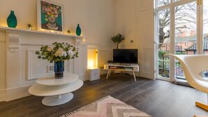 Un salon moderne avec une cheminée, un téléviseur et une grande fenêtre.