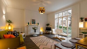Un salon moderne comprenant un canapé, une table basse, une cheminée et un coin repas avec des chaises.