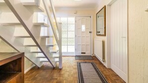 A staircase leading to a landing with a wooden floor and a white door at the end.