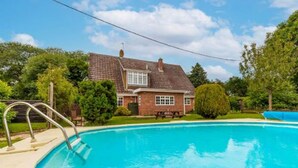 A swimming pool with a house in the background.