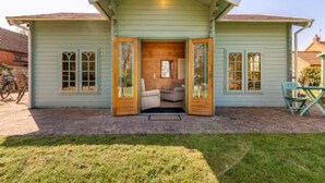 A two-story house with a front porch, wooden doors, and a brick fireplace.
